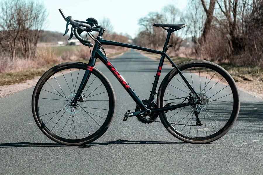 Una bicicleta de grava negra y roja en la carretera