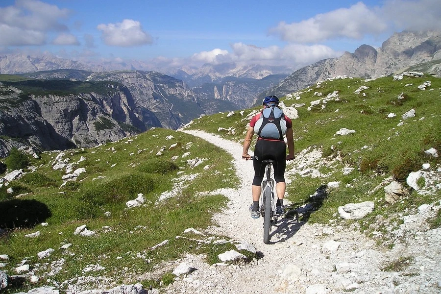 Um ciclista andando de mountain bike em uma trilha difícil