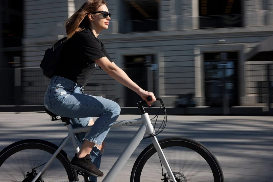 Uma mulher andando de bicicleta elétrica na estrada