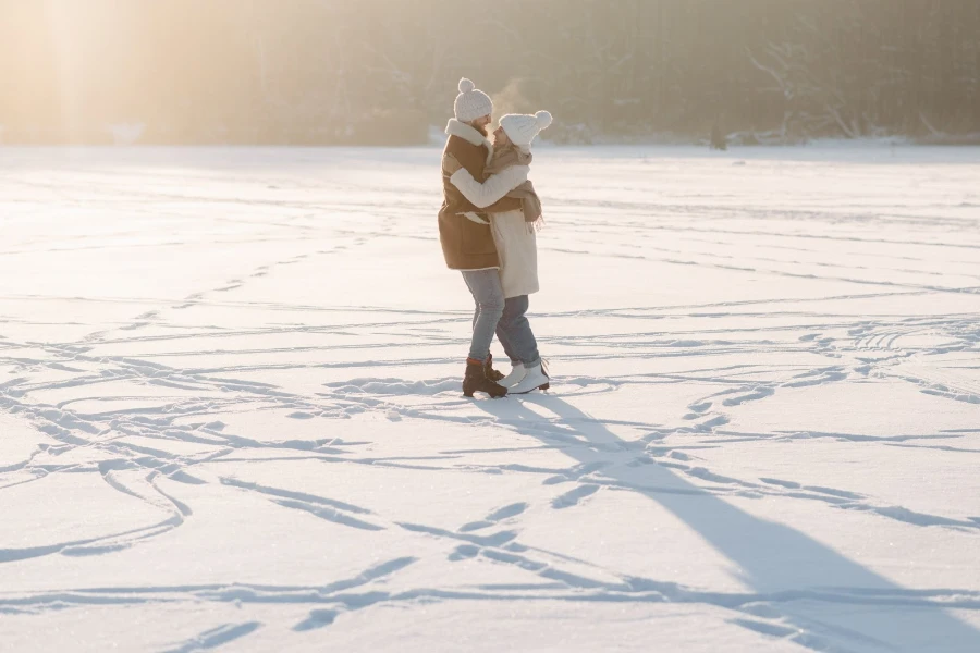 Homem e mulher patinando no gelo em trajes de inverno