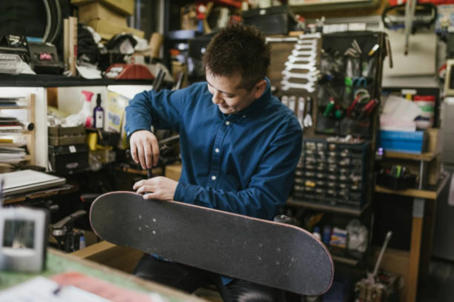 Uomo che costruisce uno skateboard in un negozio al coperto