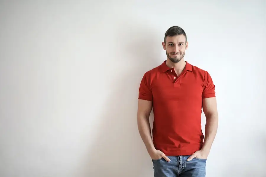 Homem posando em uma camisa polo vermelha