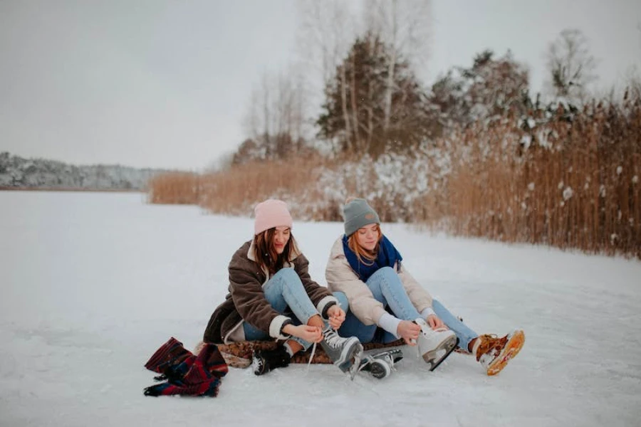 Zwei Mädchen sitzen in Winterkleidung im Schnee