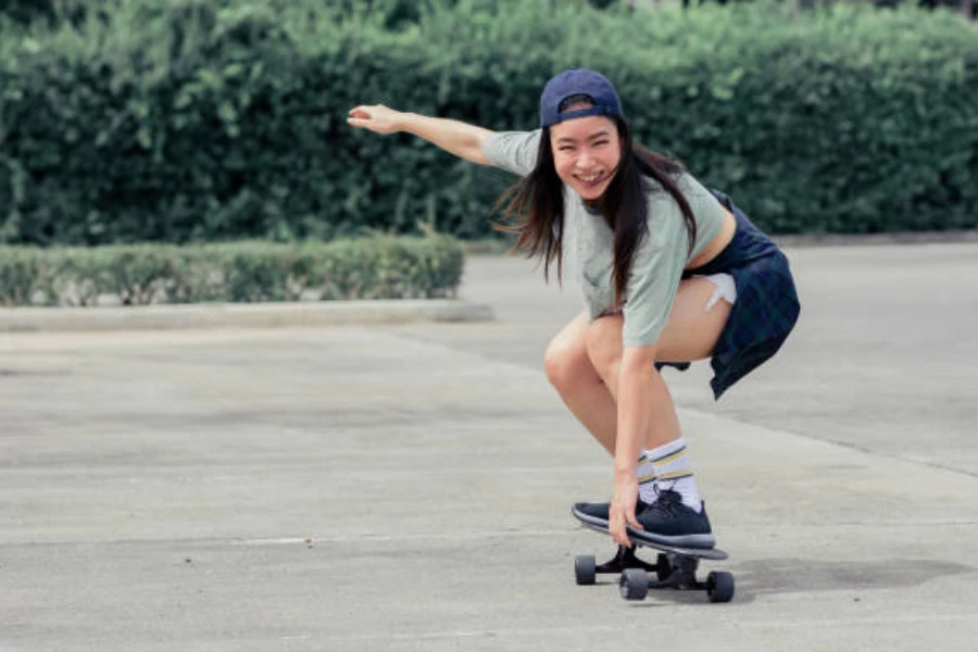 Frau fährt Skateboard auf einem leeren Parkplatz