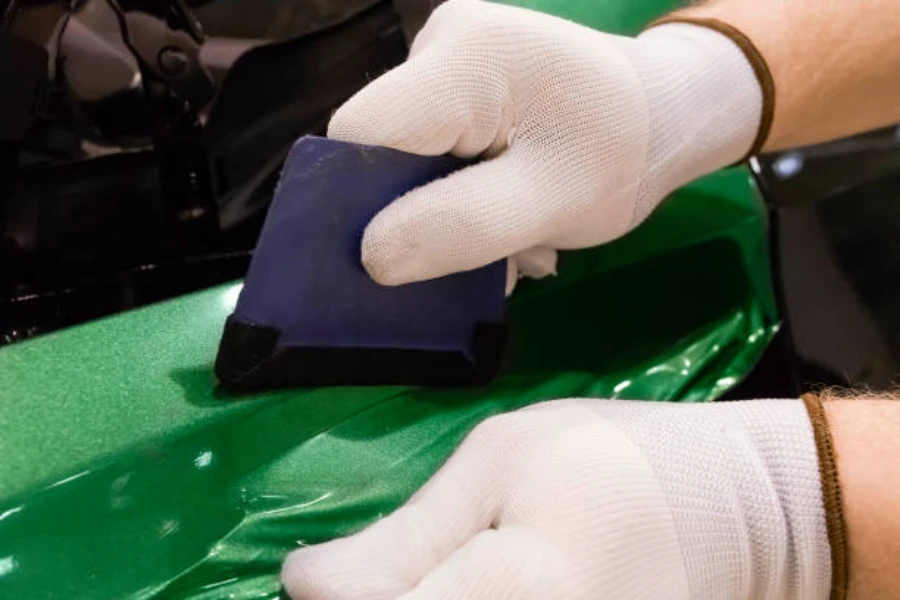 A specialist applying a vinyl film on a car