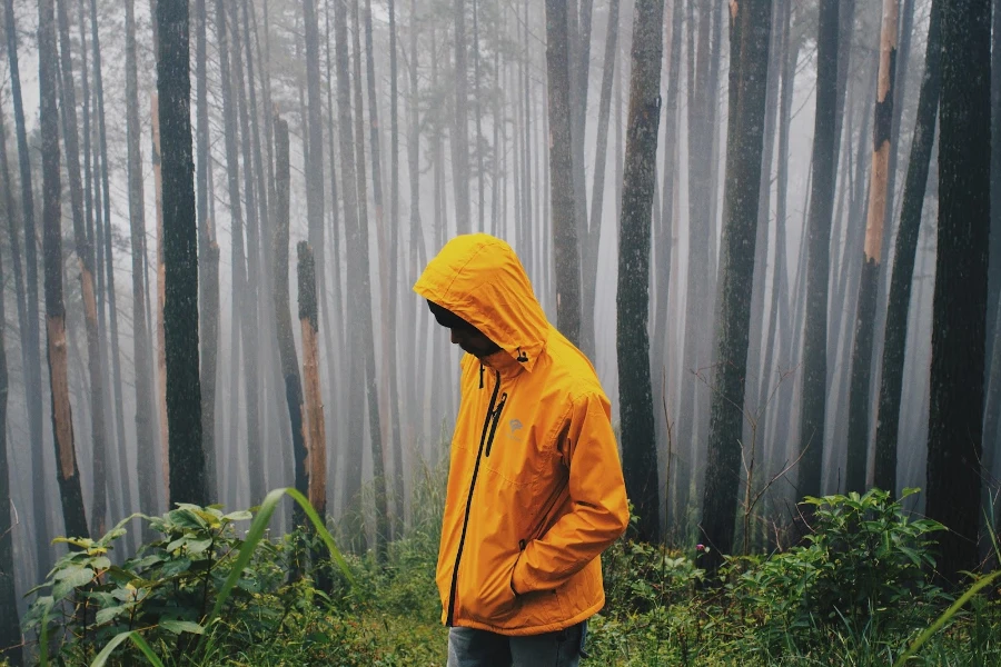 Homme portant un poncho dans les bois