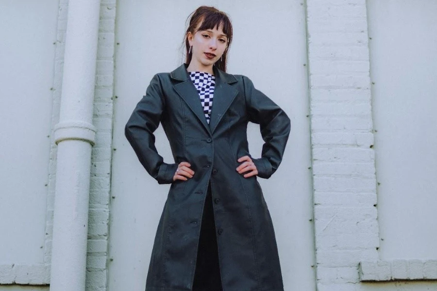 Woman holding her waist while wearing a black waterproof coat