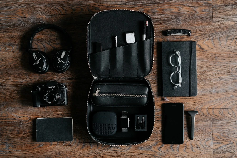 Black headphones beside camera on top of wood