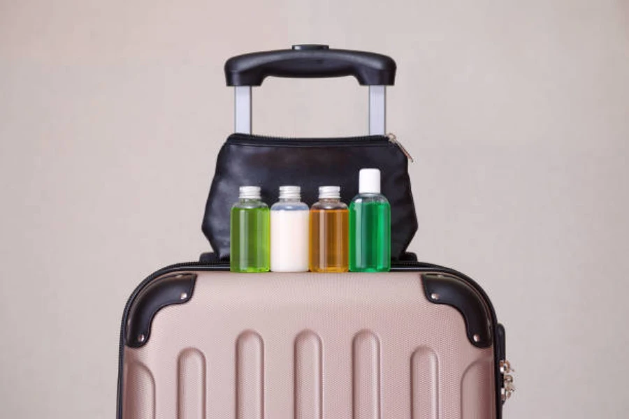 Valise marron avec mini bouteilles de shampoing assises sur le dessus