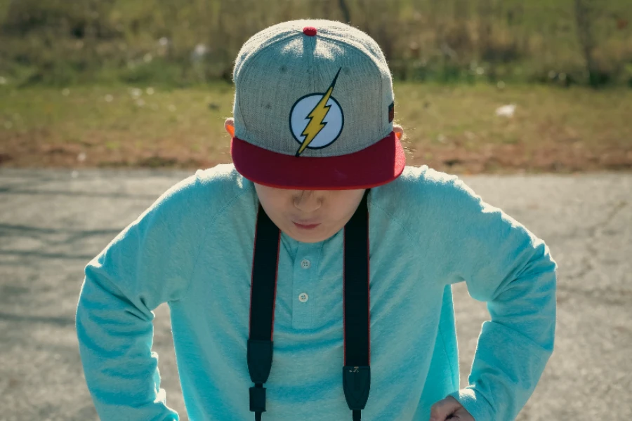 Kid in gray and red flat bill baseball hat