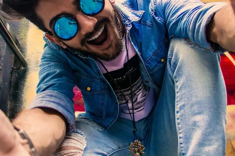 Uomo con gli occhiali e un abbigliamento denim su denim