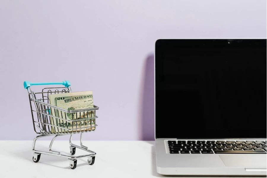 Shopping cart next to a laptop