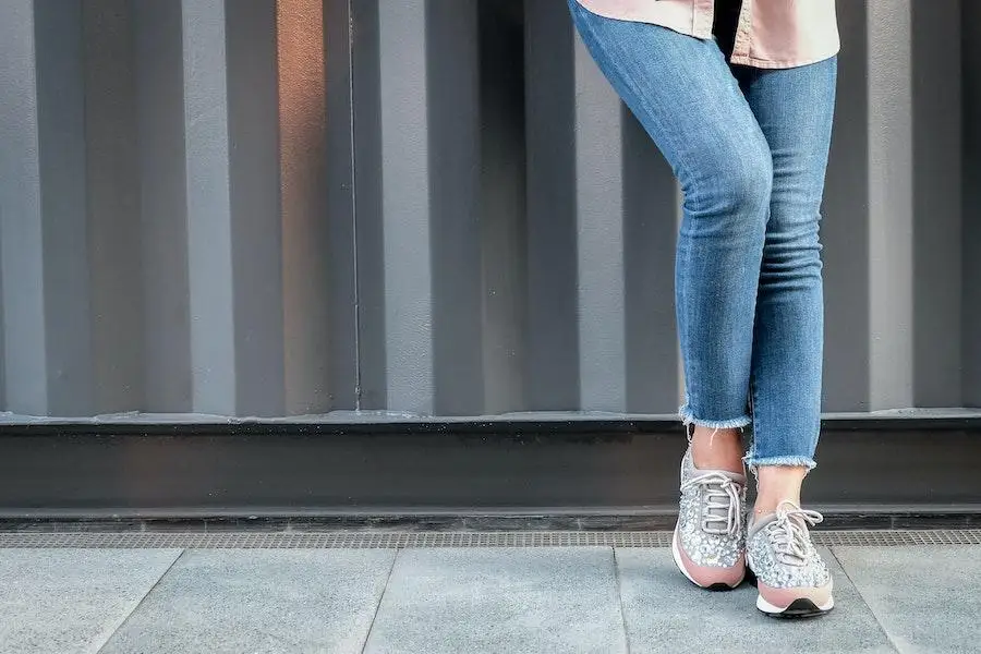 Mulher posando em jeans minimalista e top rosa brilhante