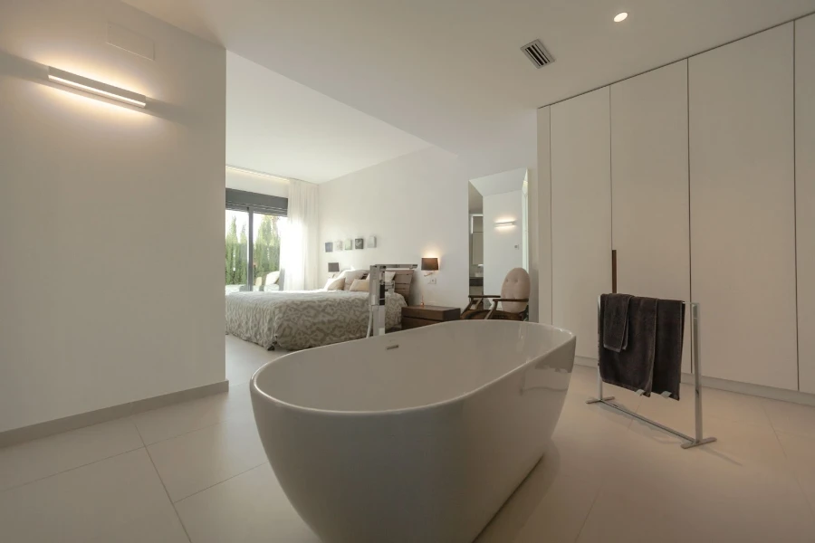 A freestanding towel warmer rack with a bathtub