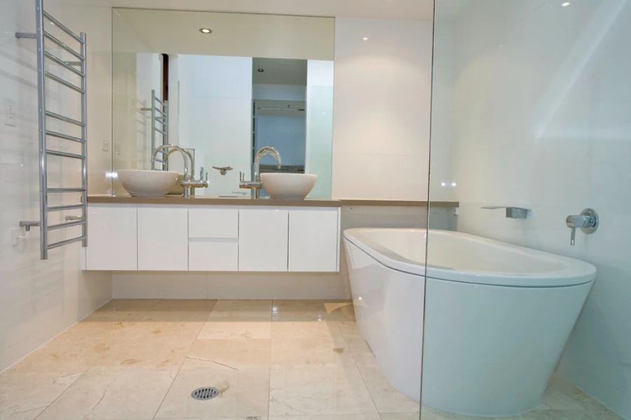 A hydronic wall-mounted towel warmer in the bathroom with white bathtub