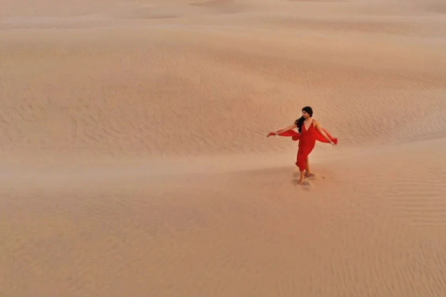 Senhora em um vestido vermelho no deserto