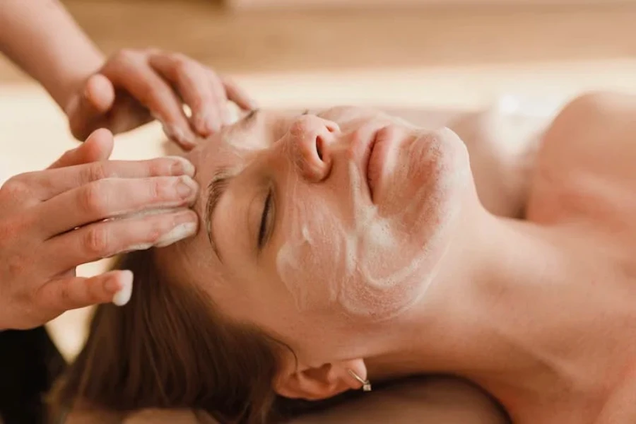 Une femme ayant une mousse exfoliante appliquée sur son visage