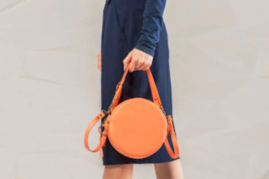 mujer, llevando, un, vestido azul, tenencia, un, estructurado, bolso