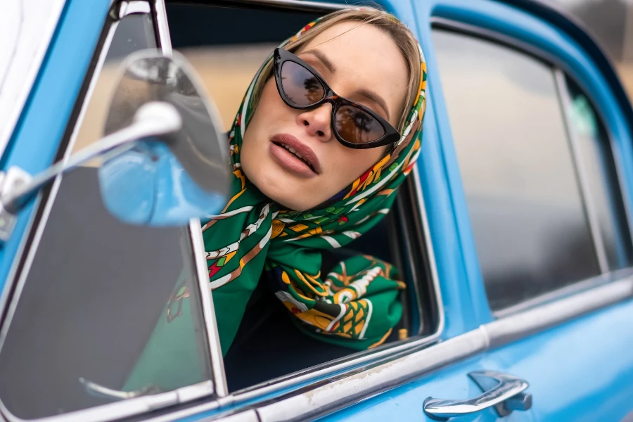 Femme portant un foulard et des lunettes de soleil œil-de-chat