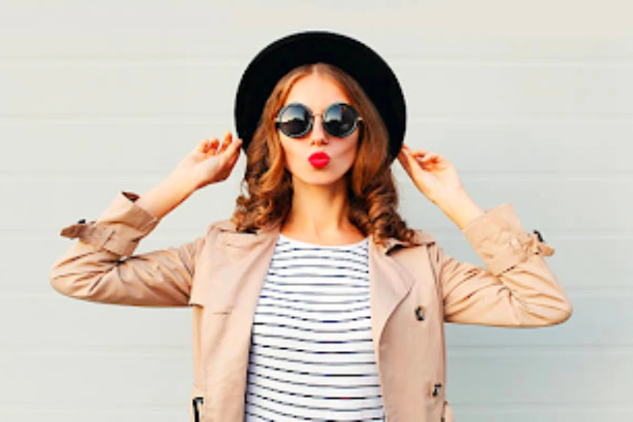 Femme portant des lunettes de soleil et un chapeau fedora