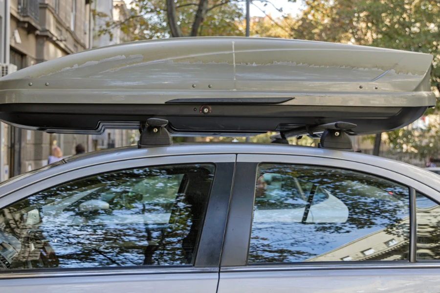 A car with a roof box parked near a building