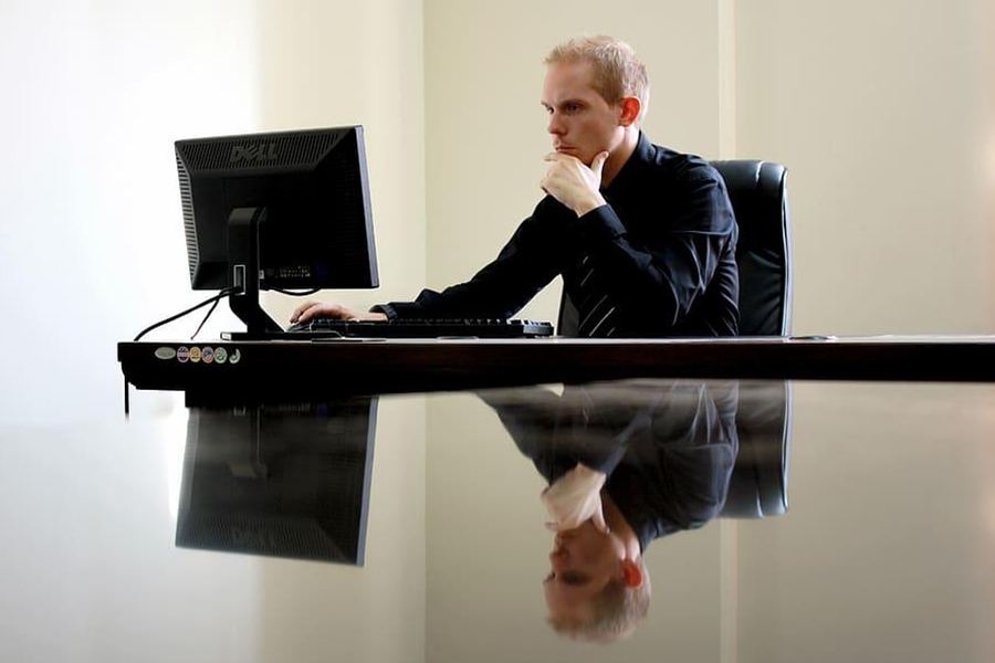 entrepreneur sitting on a desk, in front of a laptop