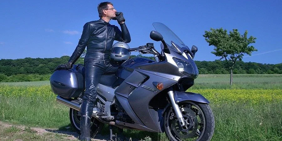 Man on a power bike rocking a black motorcycle suit