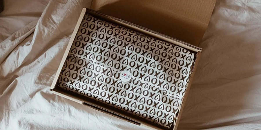 Cardboard packaging box with white and black tissue paper