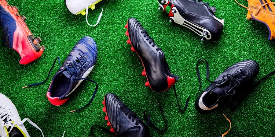 Numerous pairs of soccer shoeson the ground