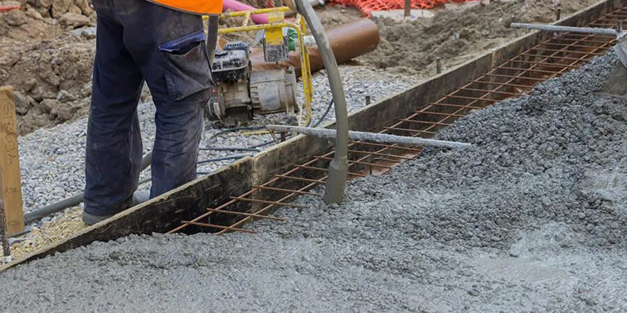 Construction worker using concrete vibrator