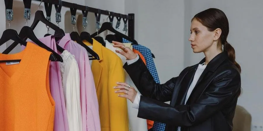 Woman in a black jacket checking clothes on a rack