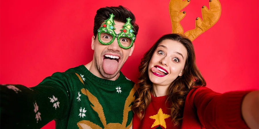 Couple posing in Christmas sweaters