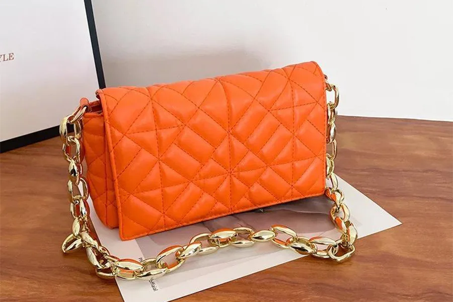 Orange handbag with a goldish chain