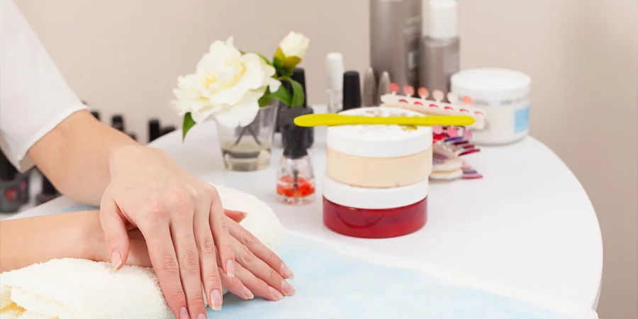 Female hands next to nail and hand care products