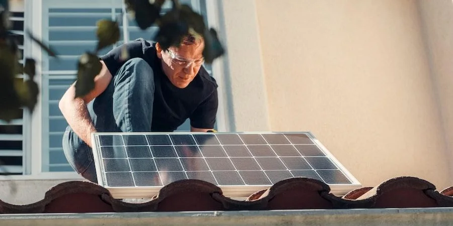 Man installing solar panel on a roof