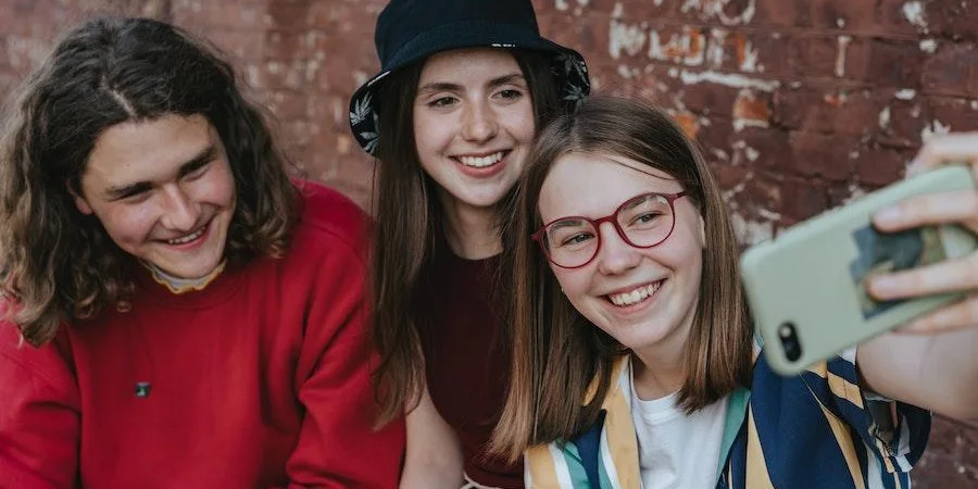 Teenagers smiling while taking selfies