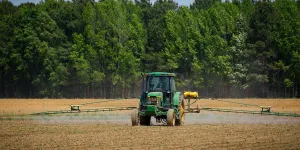A green tractor glides through a field