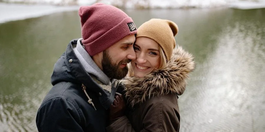 Woman and man posing with winter beanies