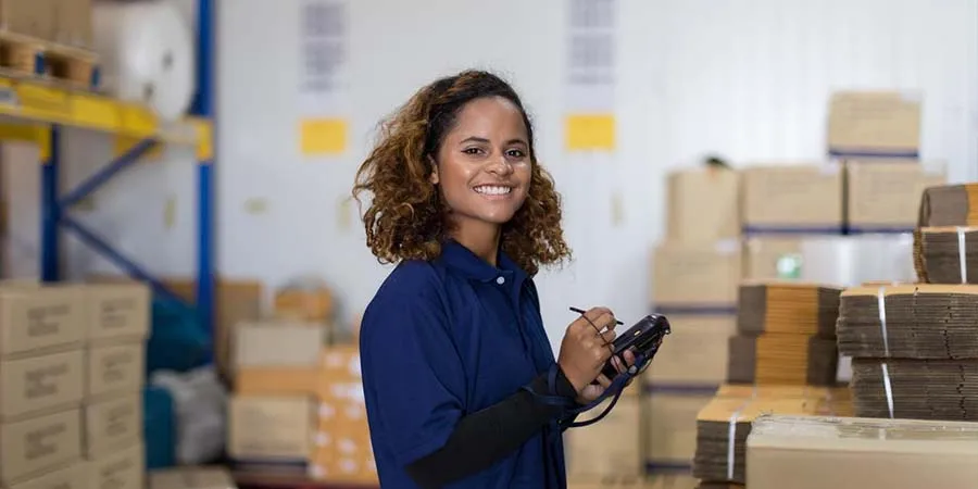 Woman in uniform working in a factory warehouse