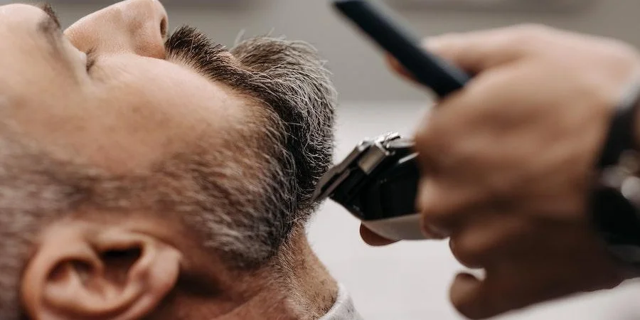Man getting a haircut from a clipper