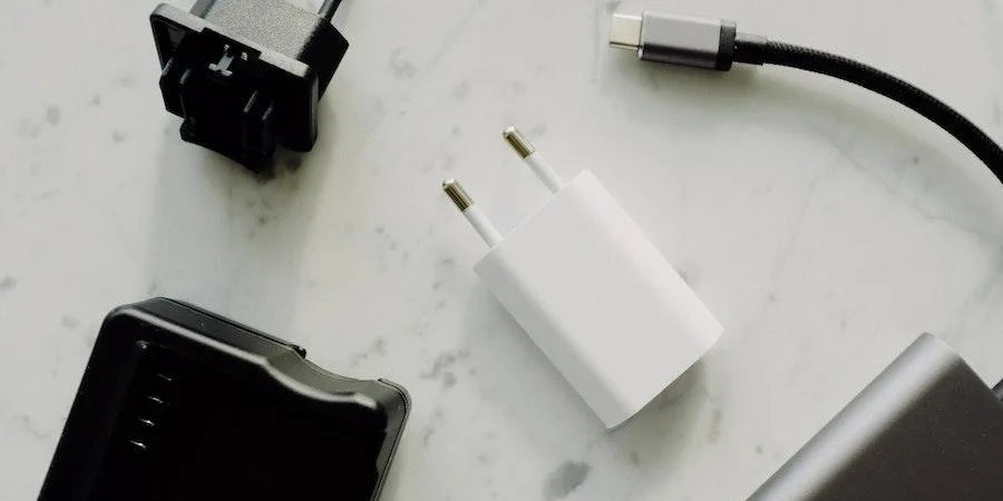 Multiple travel adapters on a white desk