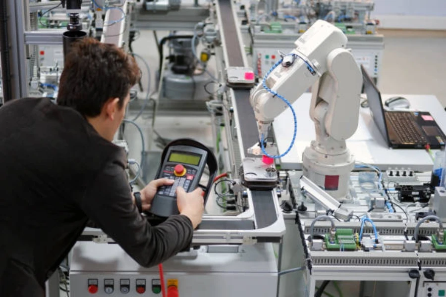 A man controlling robotic equipment in a factory