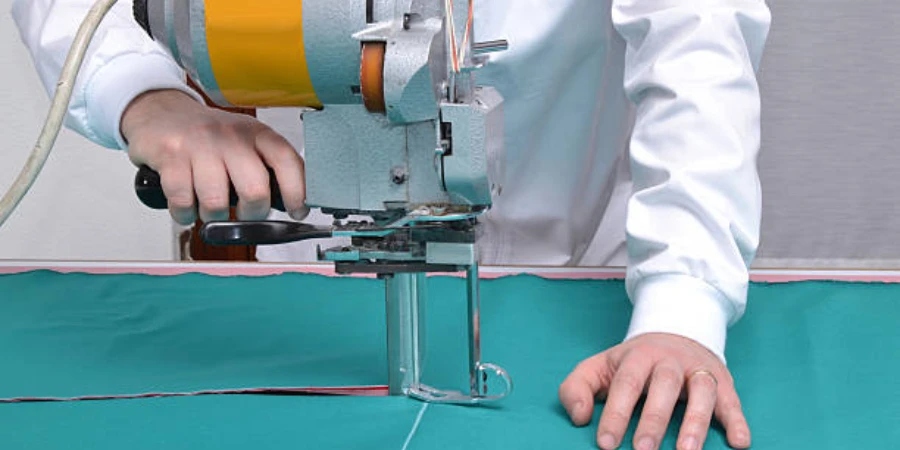 A tailor cutting fabric using a machine