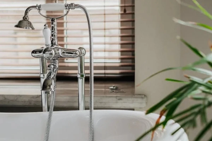 a white bathtub with a floor mounted faucet