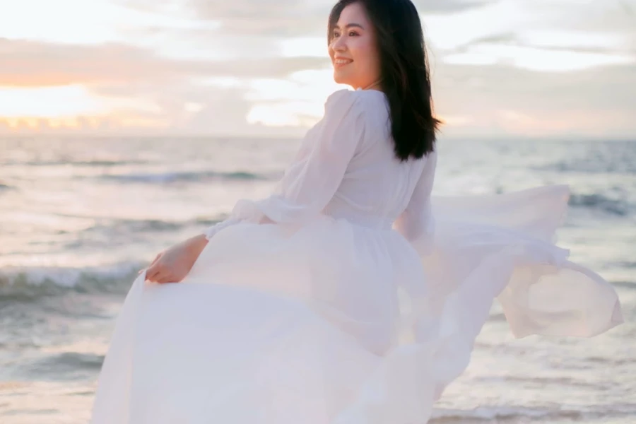 uma mulher à beira-mar vestindo um vestido de camisa