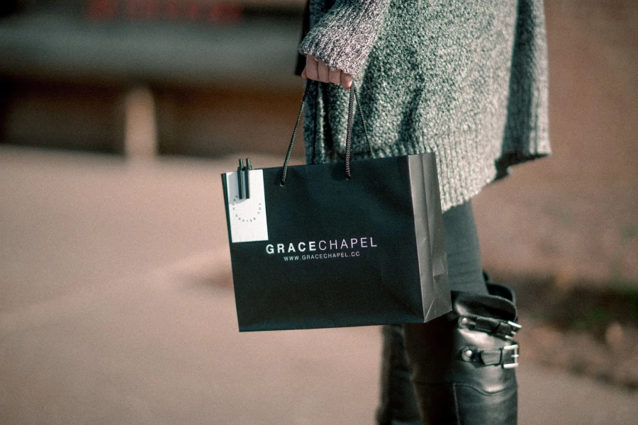 A woman out shopping in a jumper dress paired with long boots