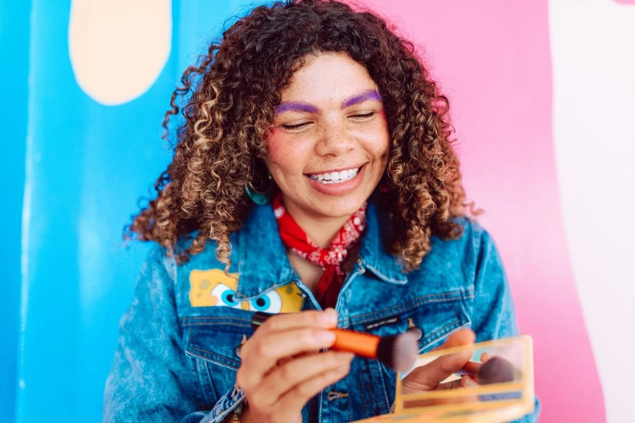 A woman putting on bright makeup