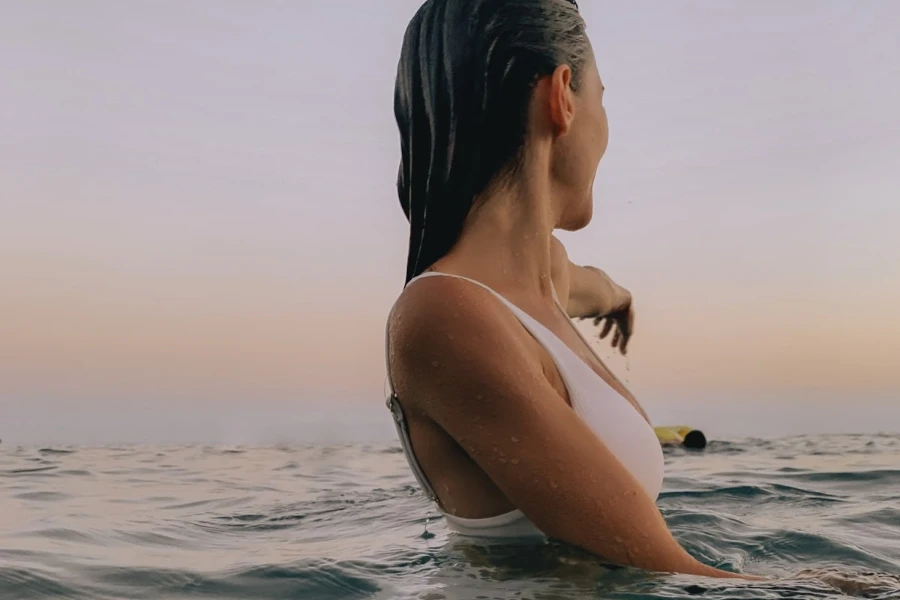 a woman swimming in the ocean wearing a swimsuit