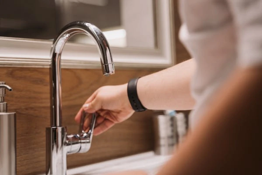 A woman turning on a single handle faucet