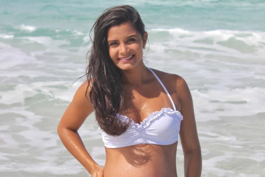 A woman wearing a white ruched bikini
